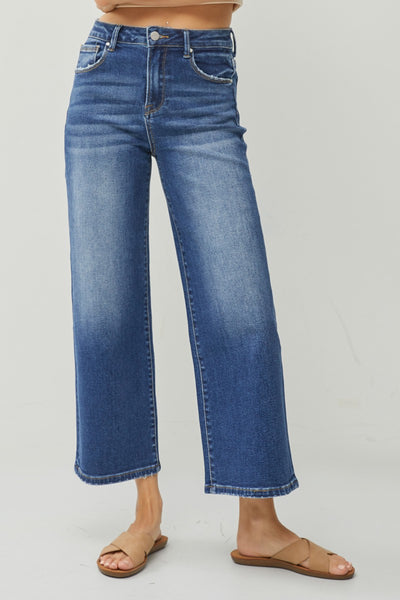 Blue jeans worn by a person on a plain background