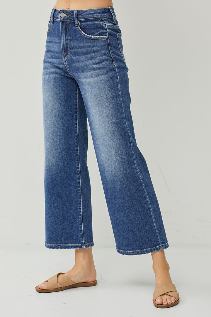 Blue jeans worn by a person on a gray background