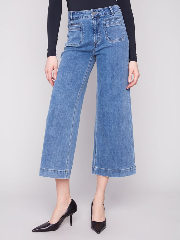 Person wearing blue wide-leg jeans on a plain background