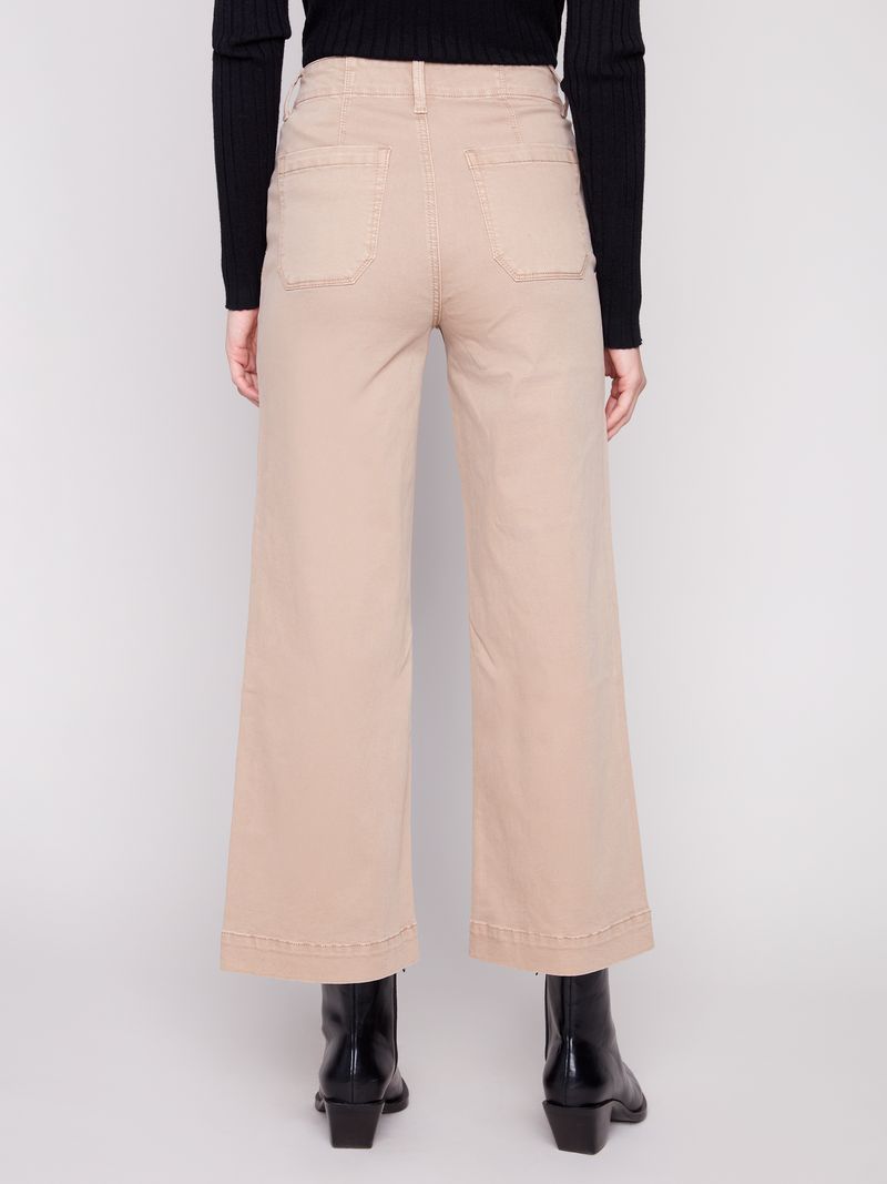 Person wearing beige wide-leg pants with a plain background