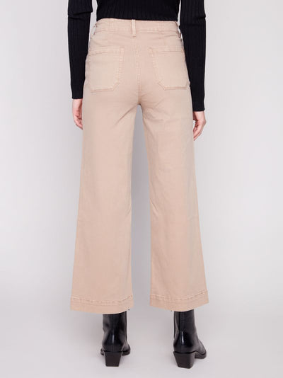 Person wearing beige wide-leg pants with a plain background