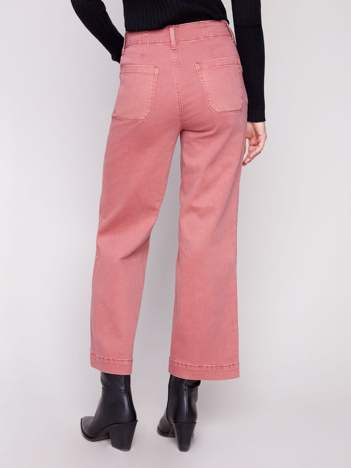 Pink jeans worn by a person on a white background