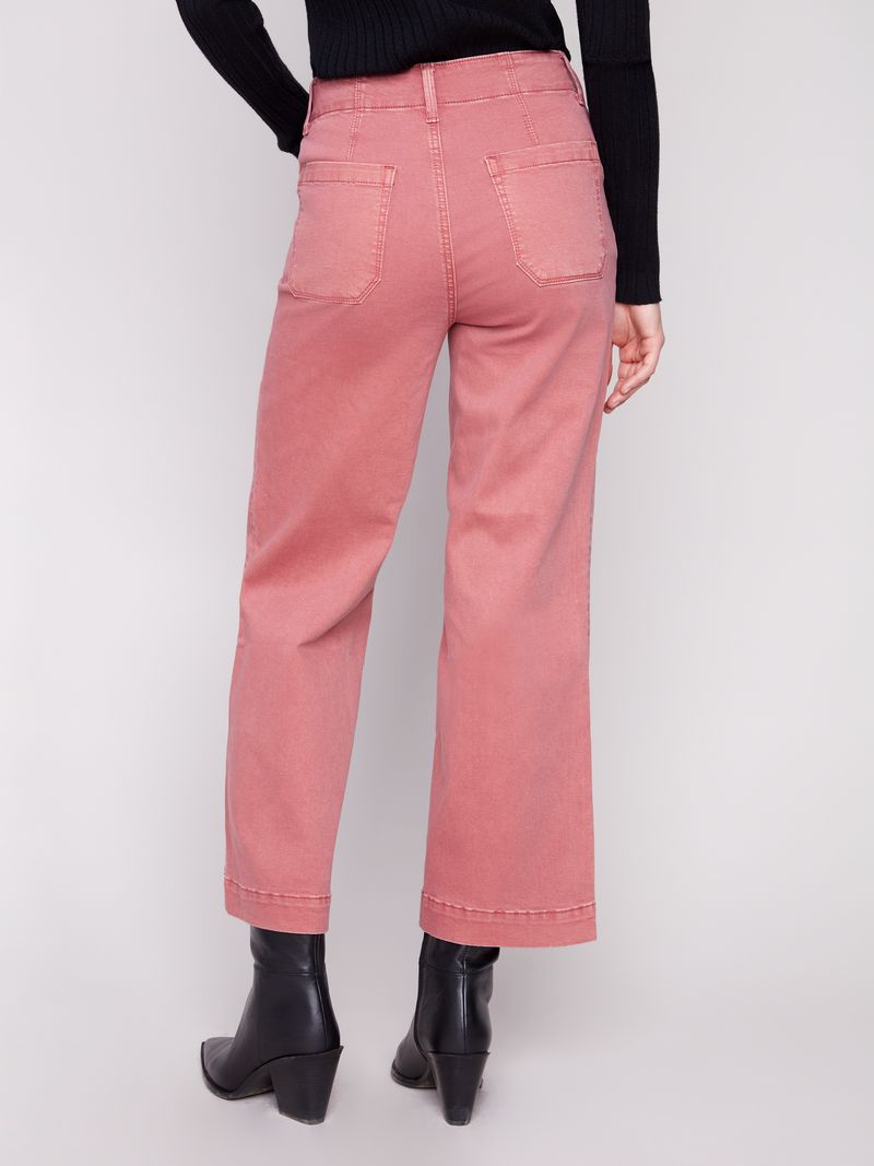 Pink jeans worn by a person on a white background