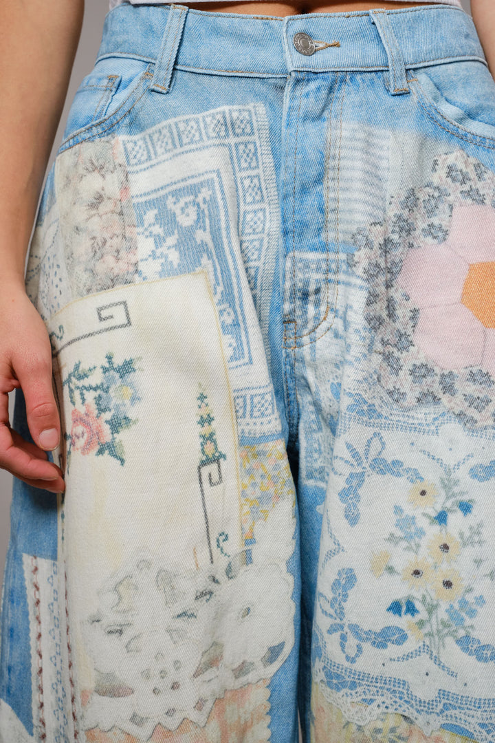 Close-up of a person wearing jeans with floral embroidery details.