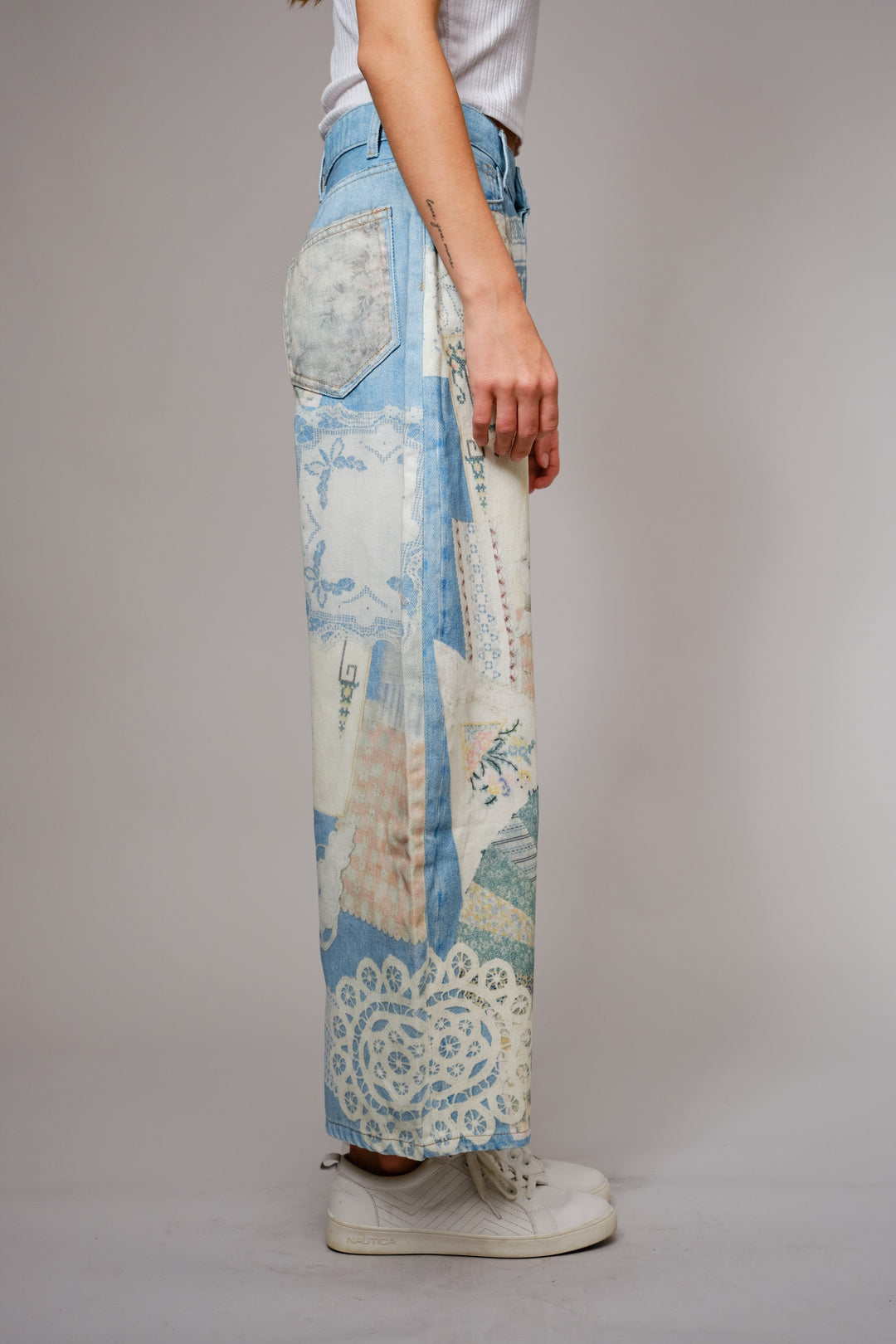 Person wearing a pair of patchwork pants with a neutral background