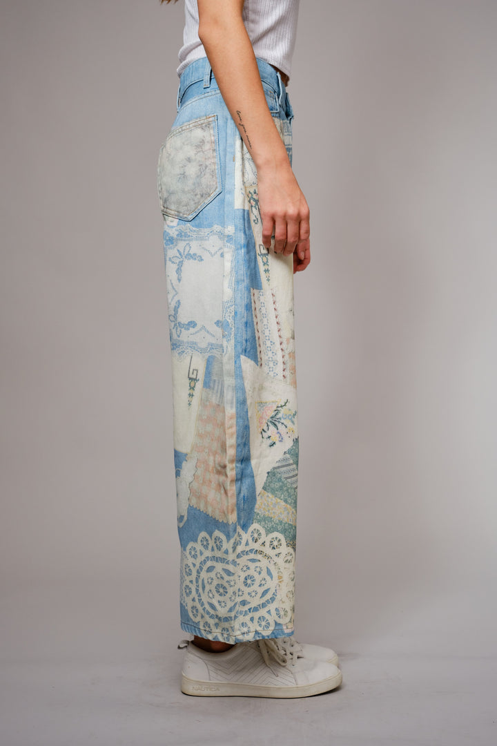 Person wearing a pair of patchwork pants with a neutral background