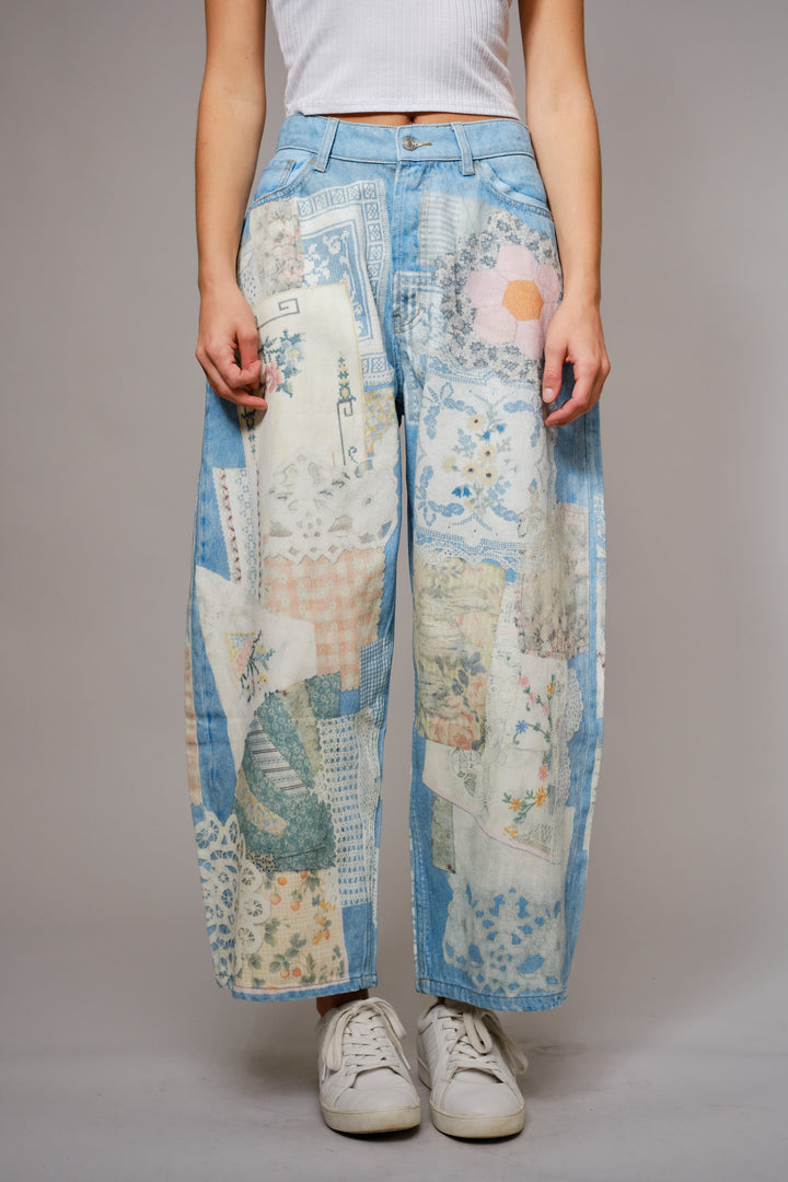 Person wearing patchwork jeans with a neutral background