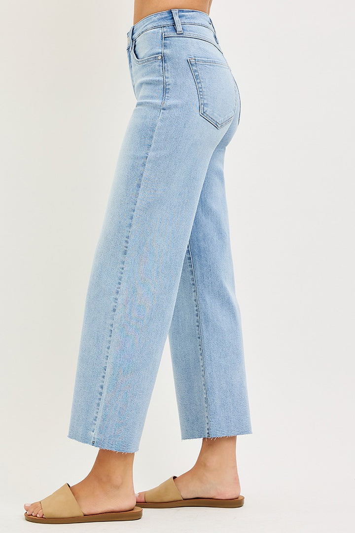 Light blue jeans worn by a person on a plain background