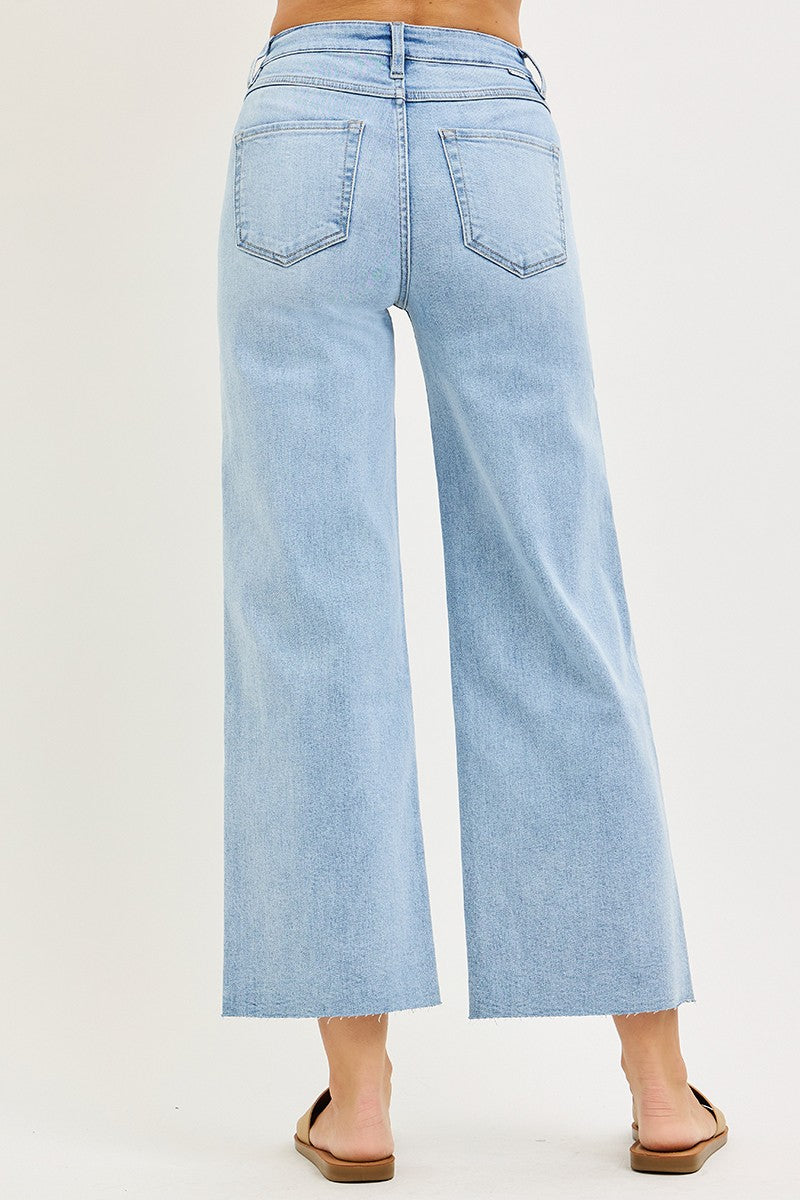 Light blue jeans worn by a person on a plain background