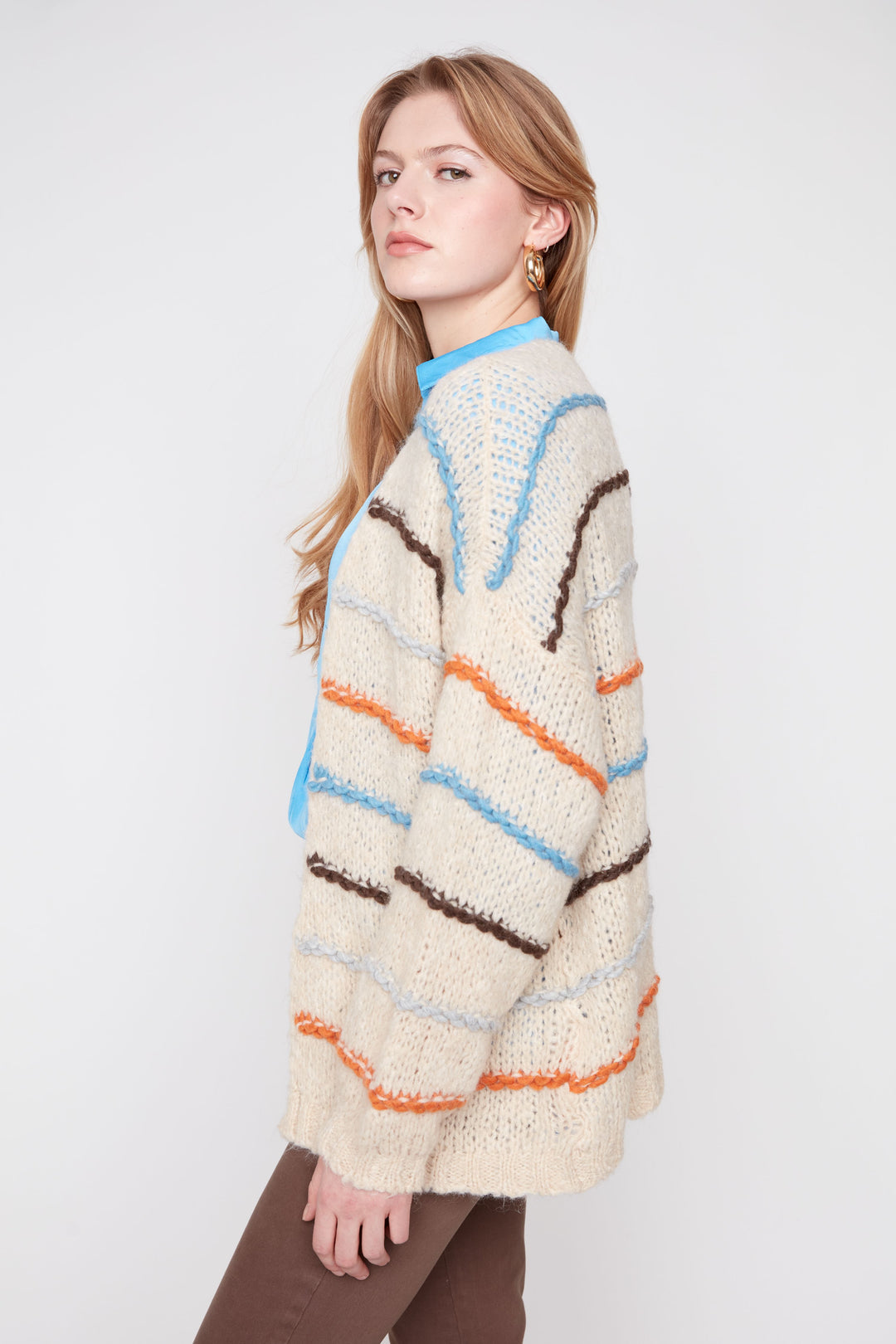 Woman wearing a colorful striped sweater on a white background