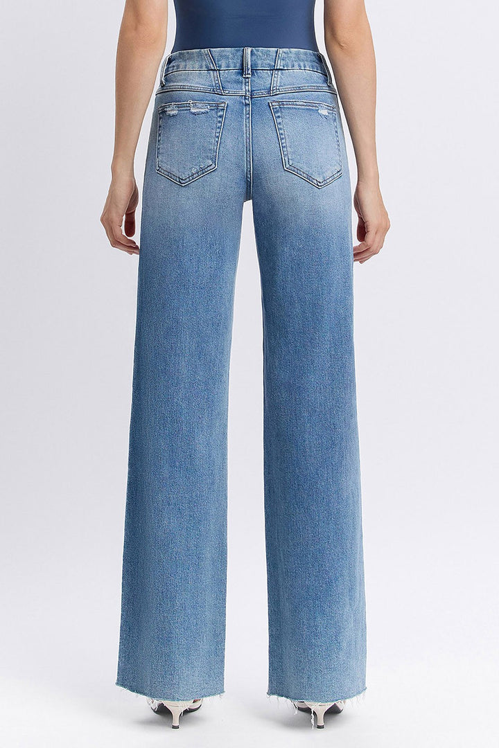 Person wearing light blue wide-leg jeans on a white background