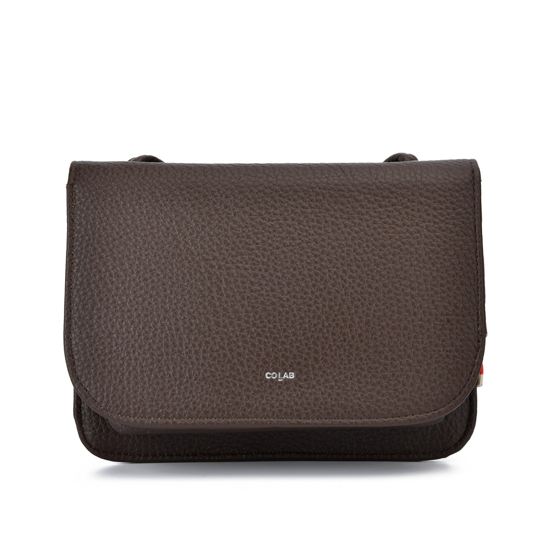 A dark brown pebbled leather shoulder bag with a flap closure and a small silver &