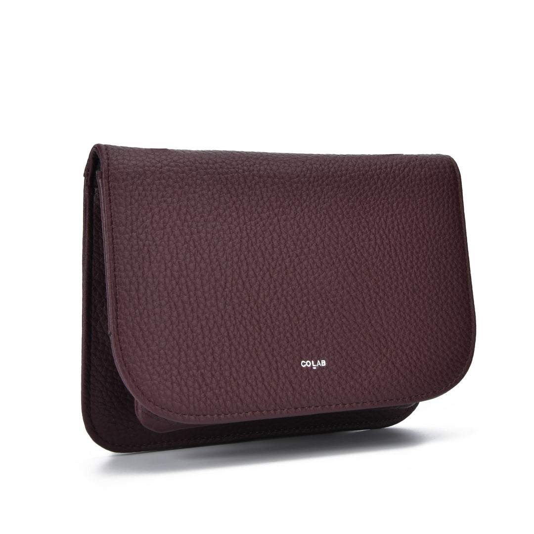 A dark burgundy pebbled leather pouch with a small white &