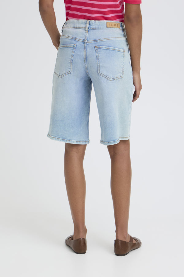 Person wearing light blue denim shorts on a white background