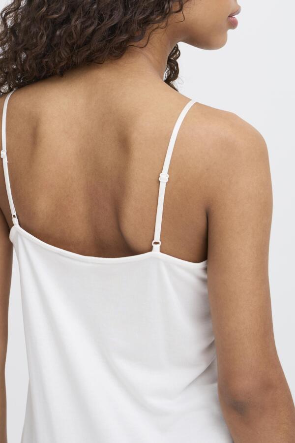 White spaghetti strap top worn by a person on a white background