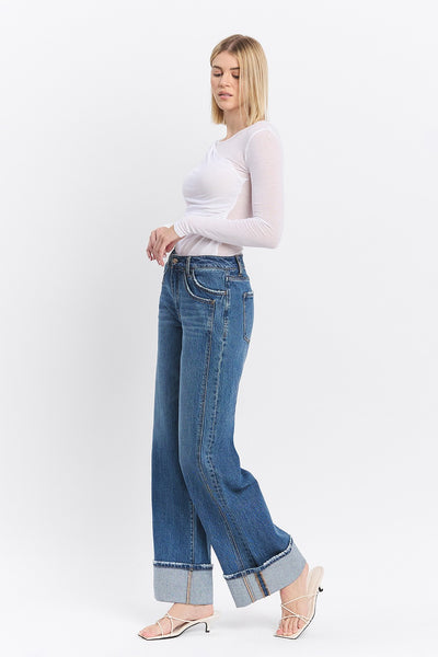 Woman wearing blue jeans and a white top on a white background