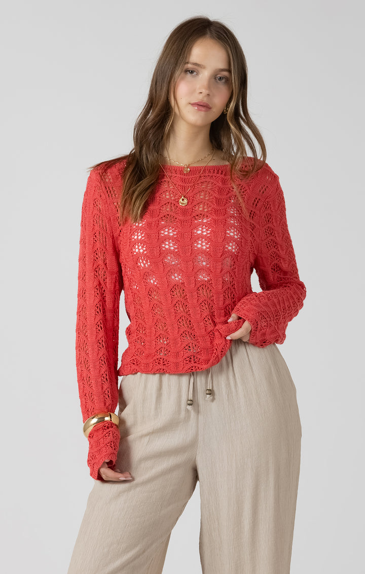 Woman wearing a red knitted sweater and beige pants on a plain background