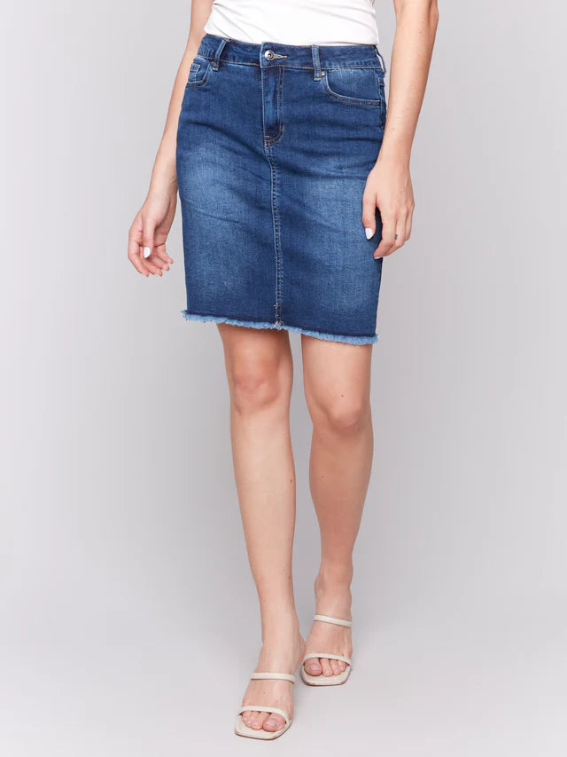 Person wearing a blue denim skirt on a plain background