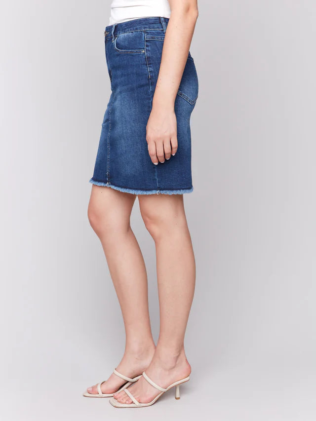 Person wearing a blue denim skirt on a plain background