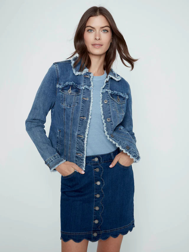 Woman wearing a denim jacket and skirt on a light gray background
