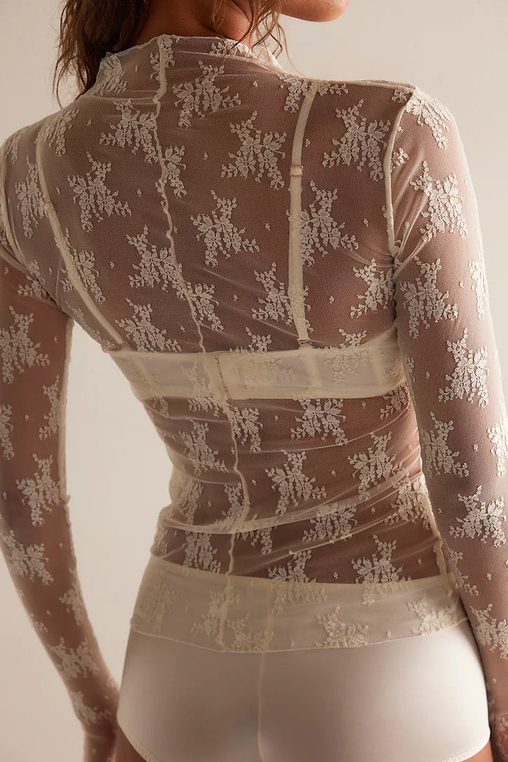 Sheer lace top with long sleeves on a plain background