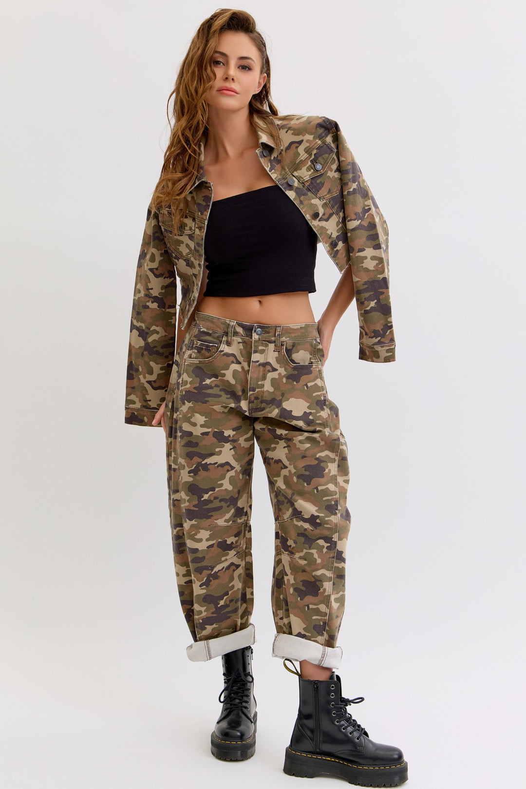 Woman wearing a camouflage outfit with a black top on a white background