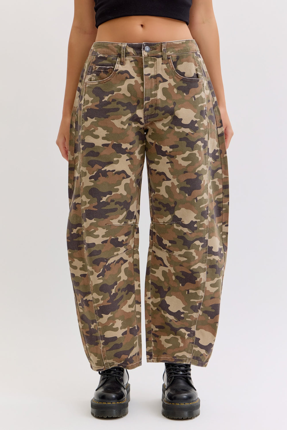 Camouflage pants worn by a person on a white background
