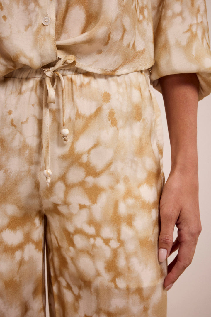 Beige and white tie-dye outfit with a drawstring waist on a plain background
