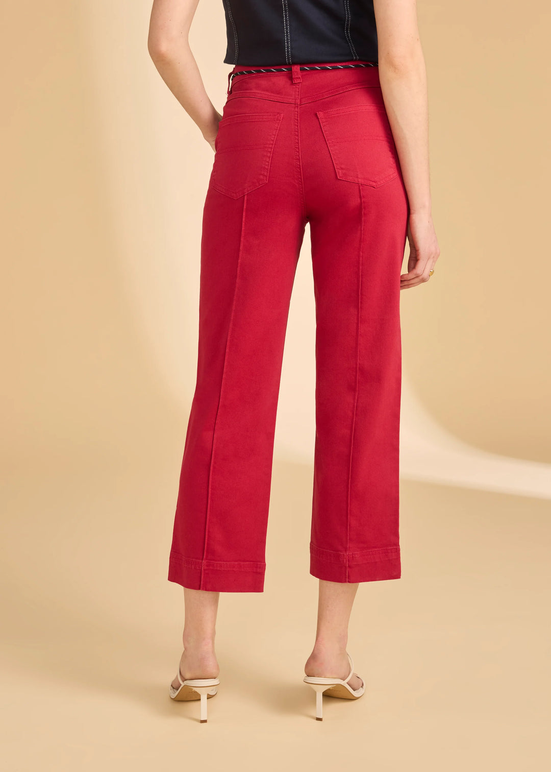 Red pants worn by a person on a beige background