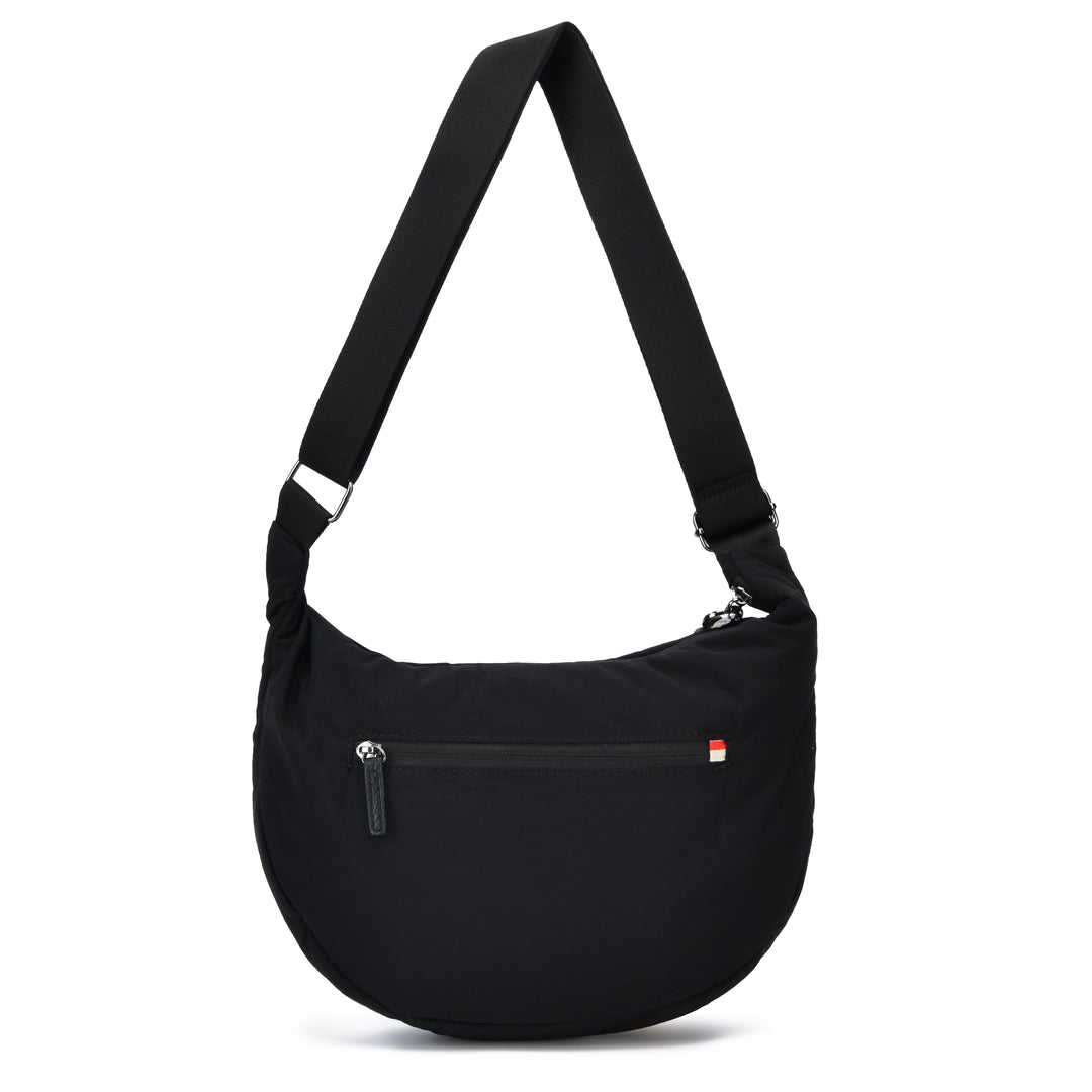 A black crescent-shaped shoulder bag with an adjustable shoulder strap, a front zippered pocket, and a small red and white logo tab on the right side, shown against a plain white background.