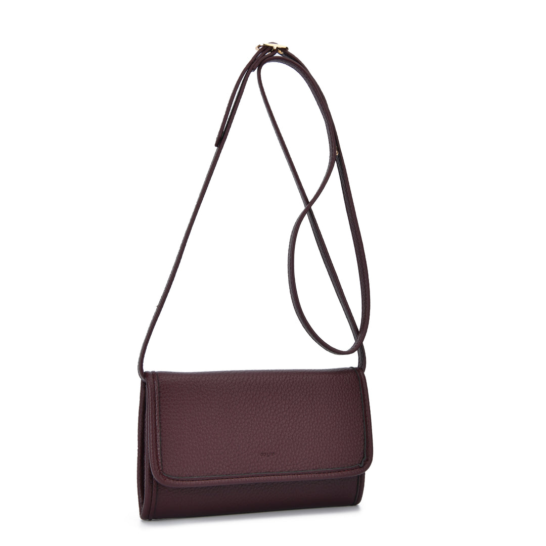 A dark plum-colored pebbled leather crossbody bag with a long adjustable shoulder strap, shown against a plain white background.