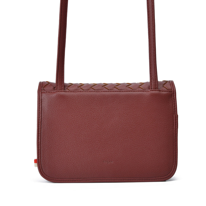 A burgundy pebbled leather shoulder bag with a braided top detail and a thin shoulder strap, shown against a plain white background.