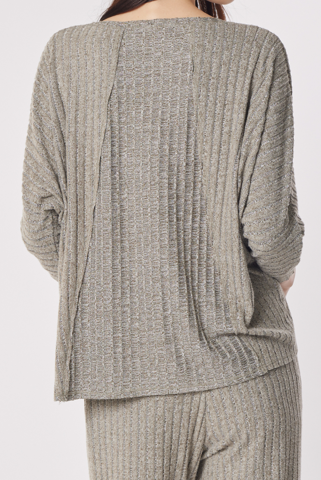 A person shown from the back wearing a ribbed knit two-piece loungewear set in a heathered taupe-gray color, featuring a long-sleeve top and matching pants against a plain light gray background.
