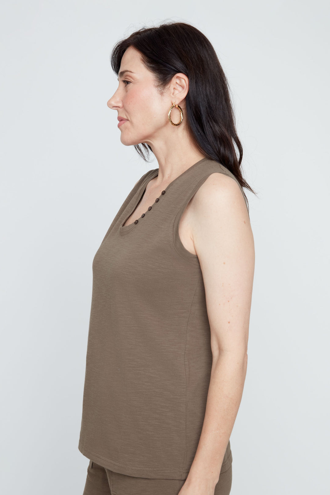 Woman wearing a brown sleeveless top and shorts on a white background