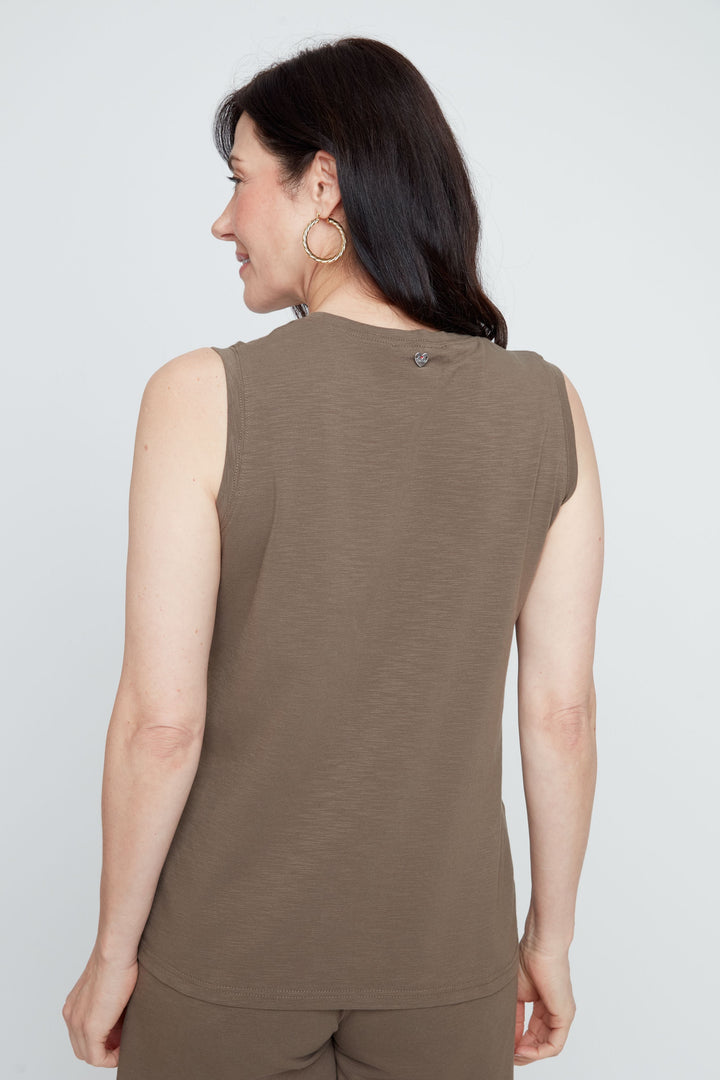 Woman wearing a brown sleeveless top and shorts on a white background
