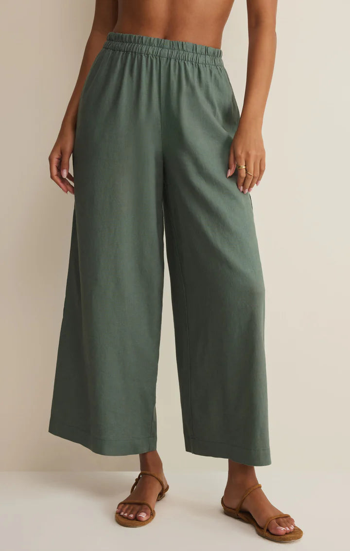 Person wearing green wide-leg pants on a plain background