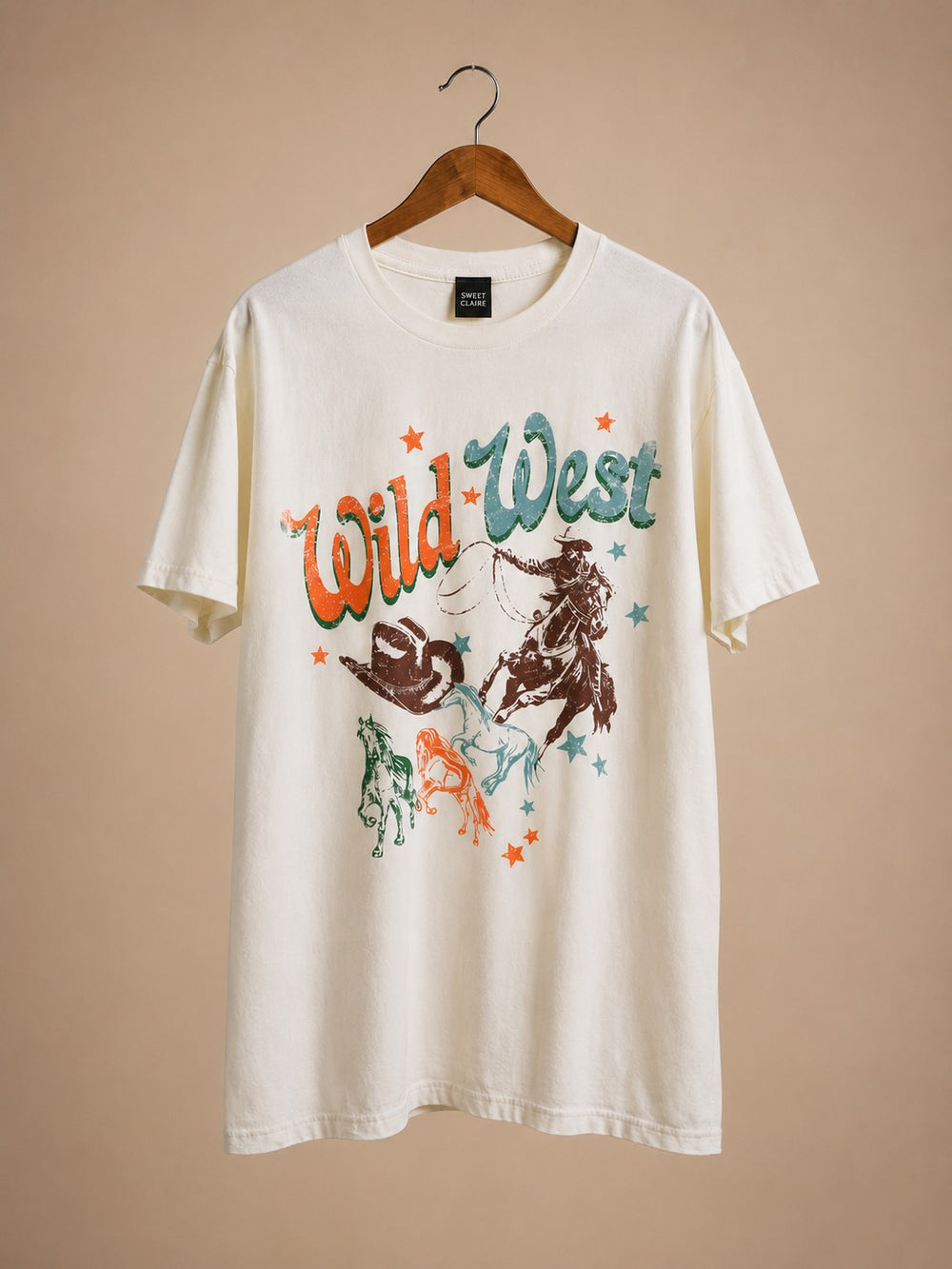 White t-shirt with 'Wild West' graphic design on a beige background