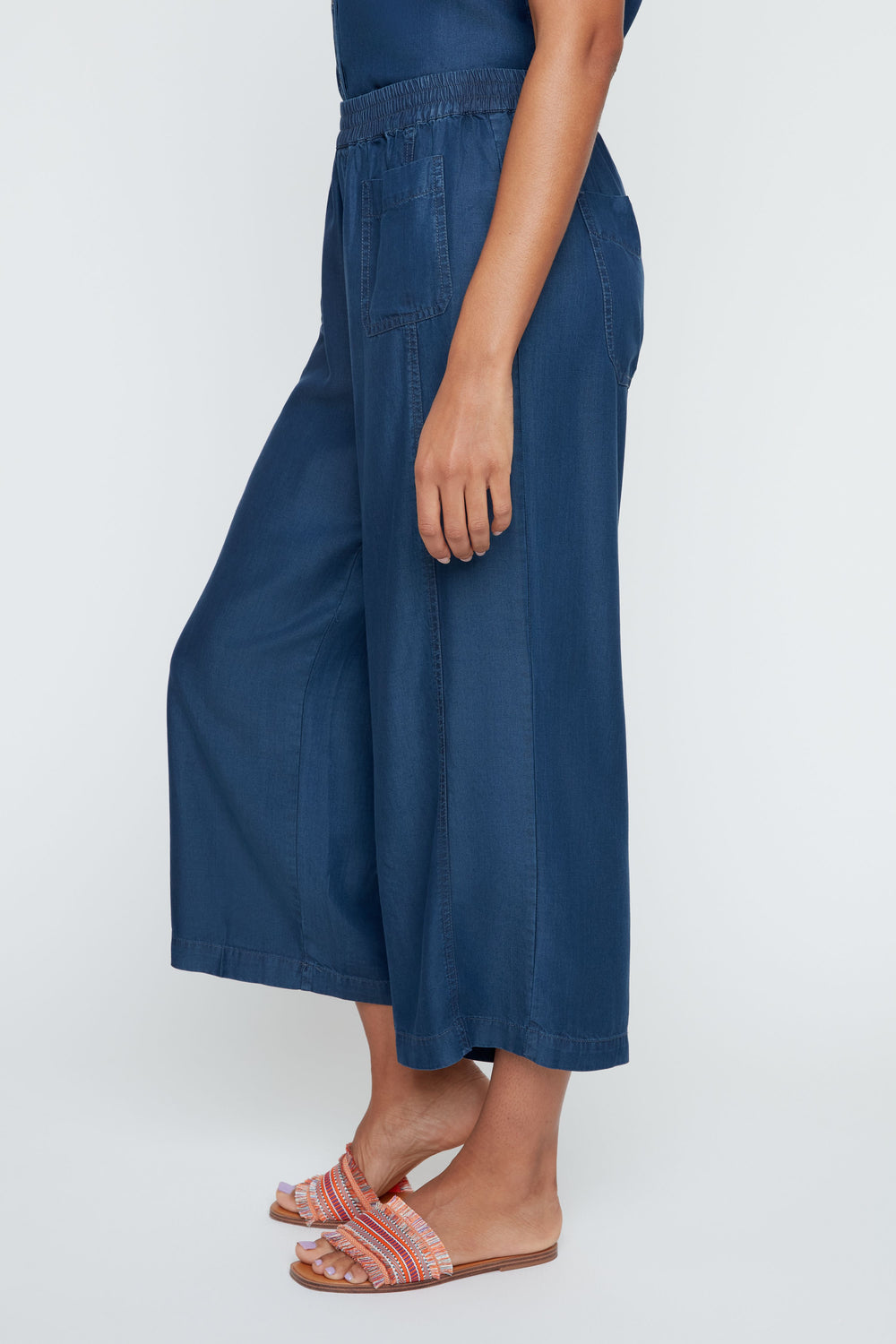 Person wearing blue wide-leg pants on a white background