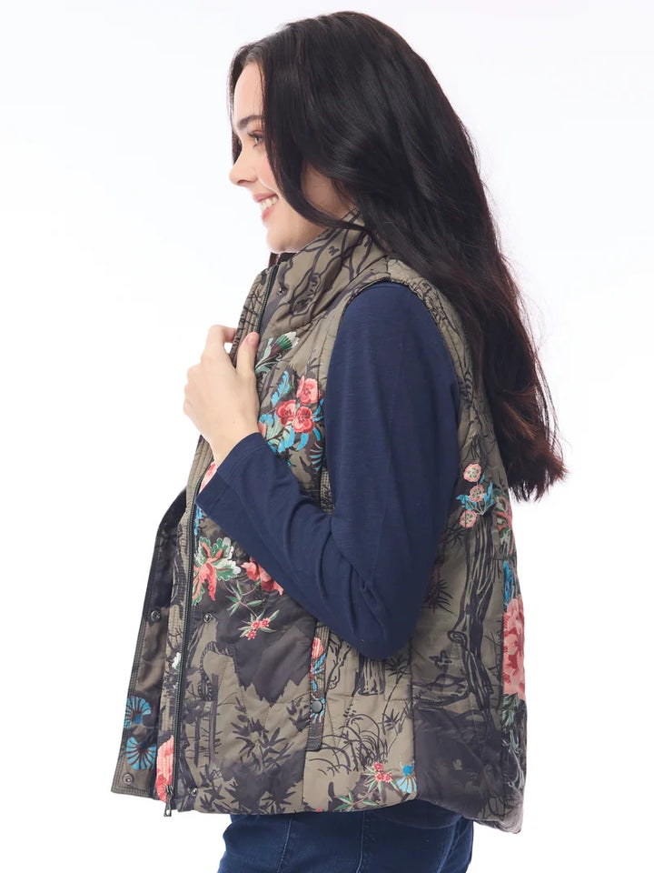 Woman wearing a floral patterned vest over a dark blue shirt on a white background