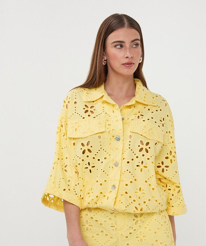 Woman wearing a yellow lace outfit on a white background