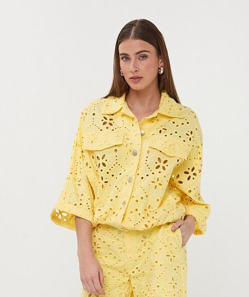 Woman wearing a yellow outfit with a matching jacket and shorts on a white background
