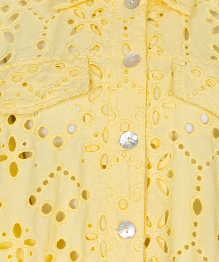 Close-up of a yellow lace garment with floral patterns and button details.