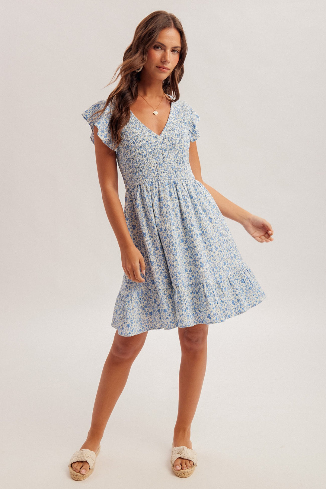 Woman wearing a blue floral dress on a white background