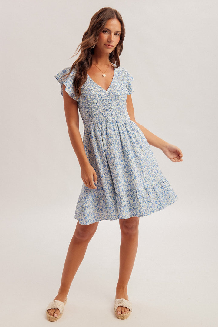 Woman wearing a blue floral dress on a white background