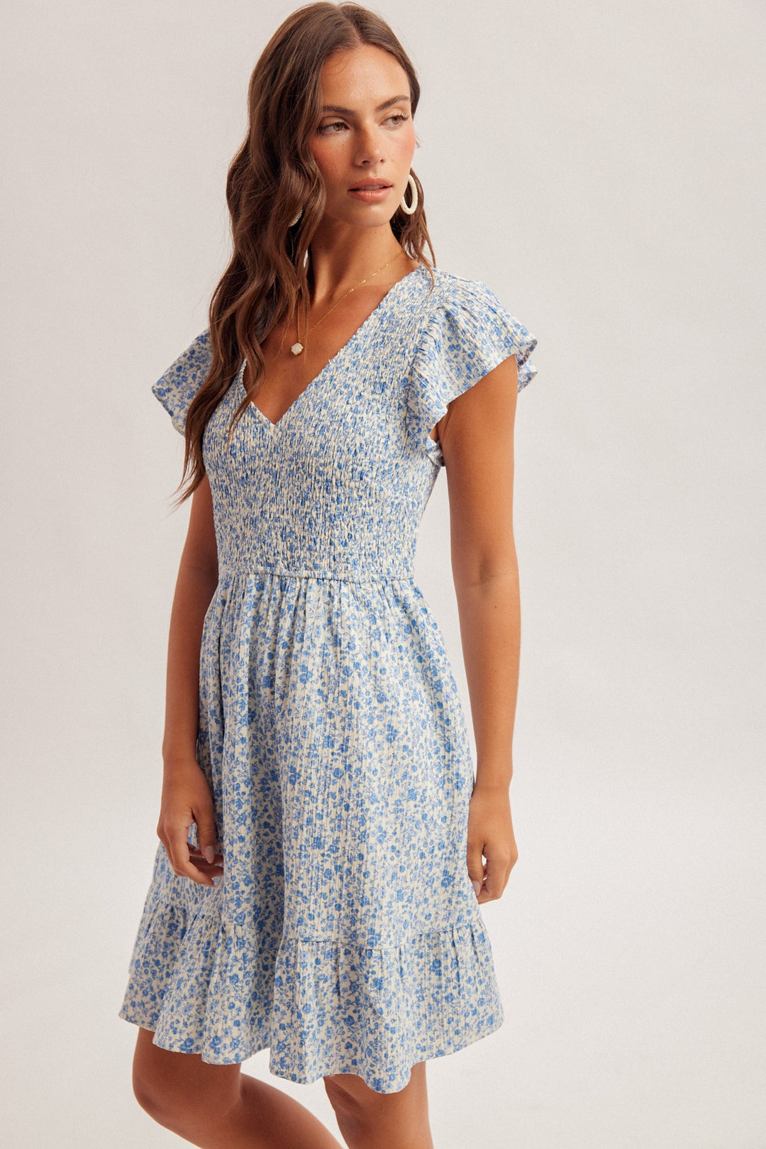 Woman wearing a blue floral dress on a white background