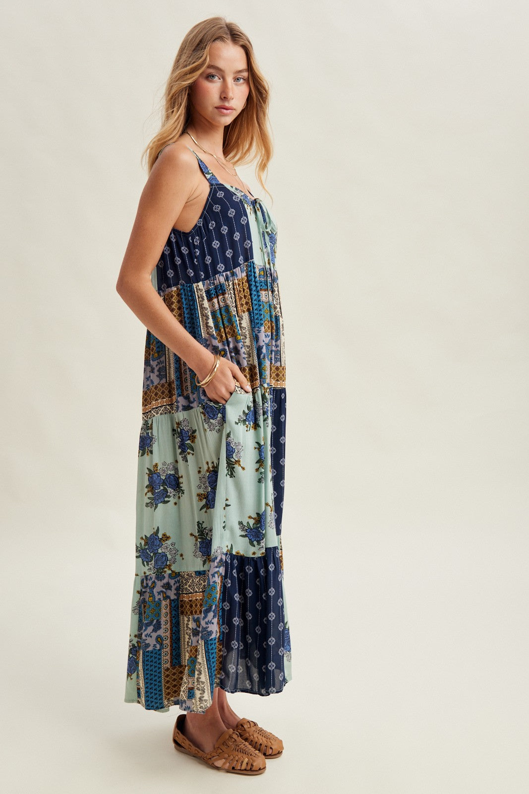 Woman wearing a patchwork dress with a neutral background