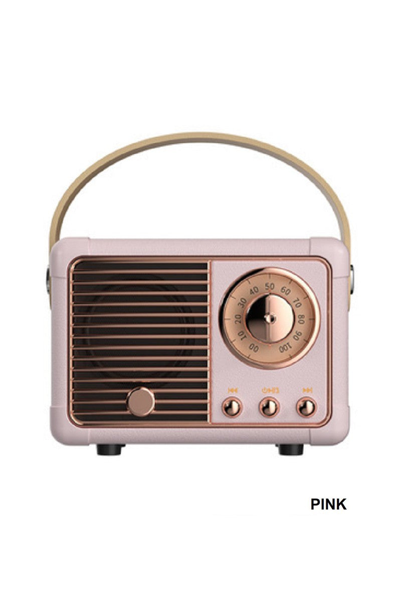 Pink vintage-style radio with gold accents on a white background