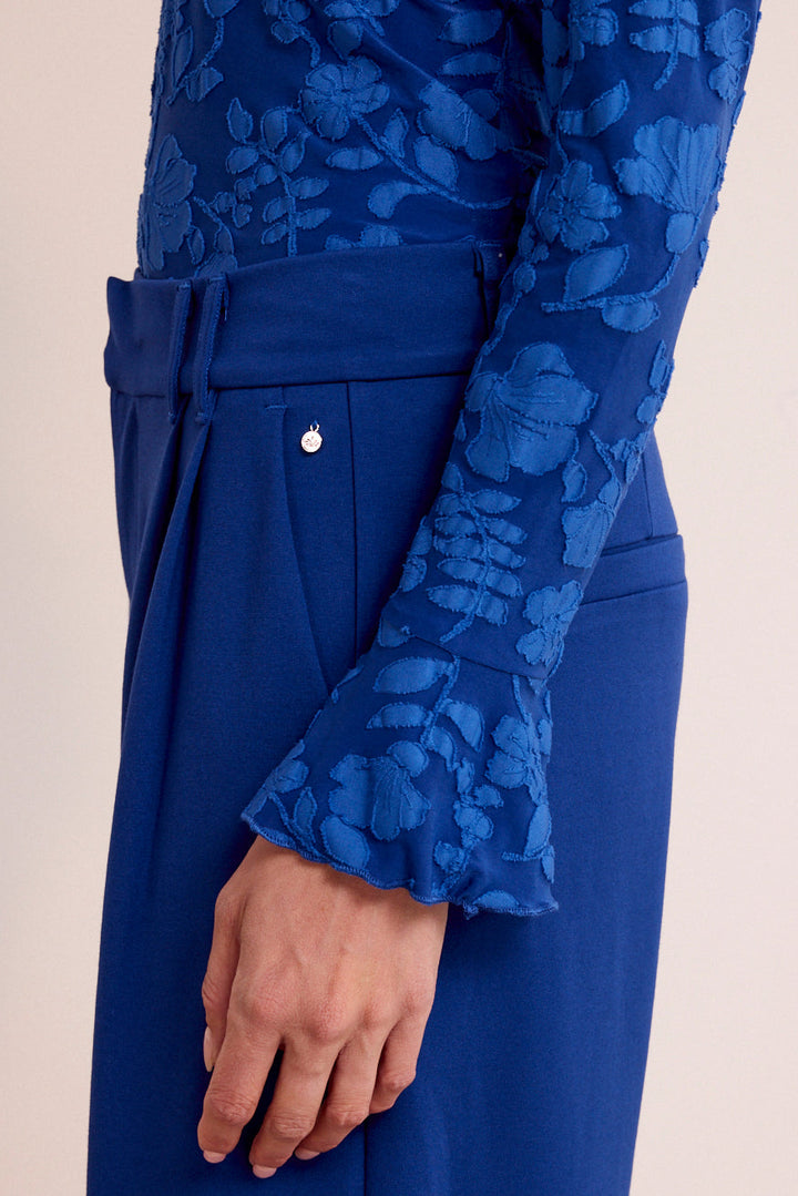 Blue floral-patterned long-sleeve top and pants on a beige background