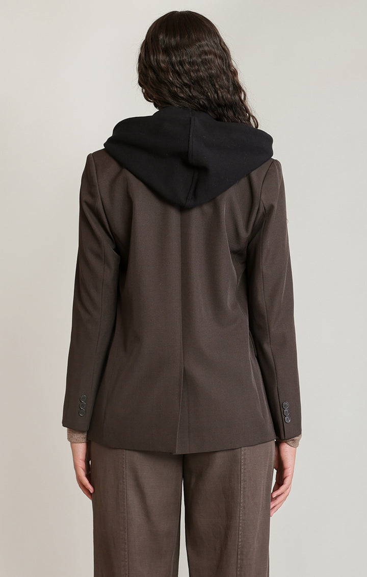 Person wearing a brown coat with a black hood on a plain background