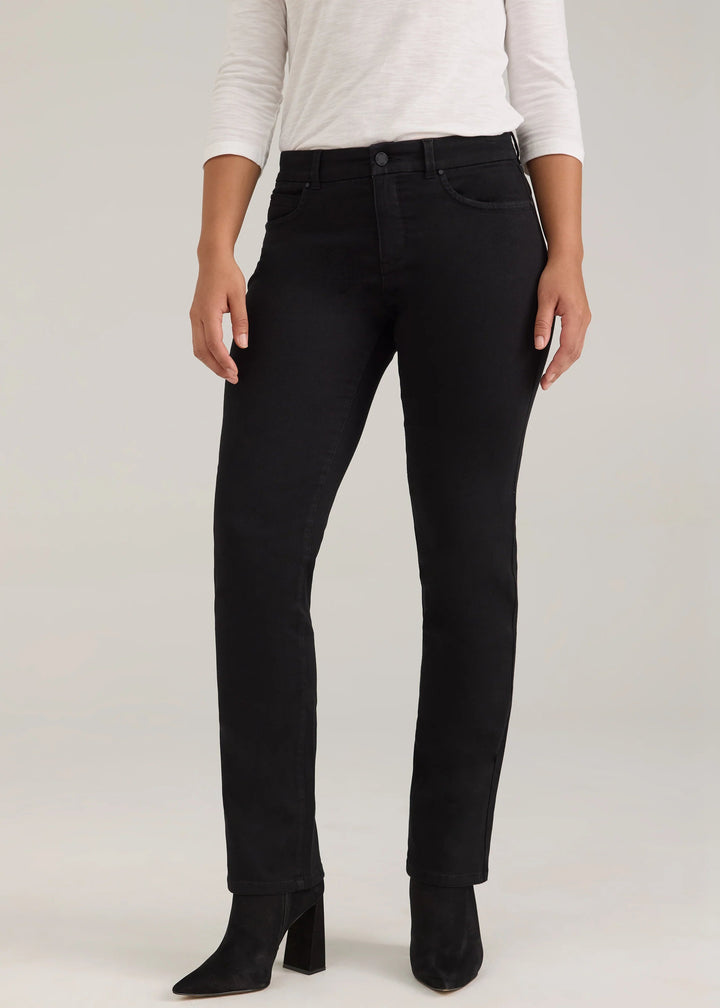 A model wearing black slim-fit jeans, a white long-sleeve top, and black pointed-toe heeled boots, standing against a light gray studio background.